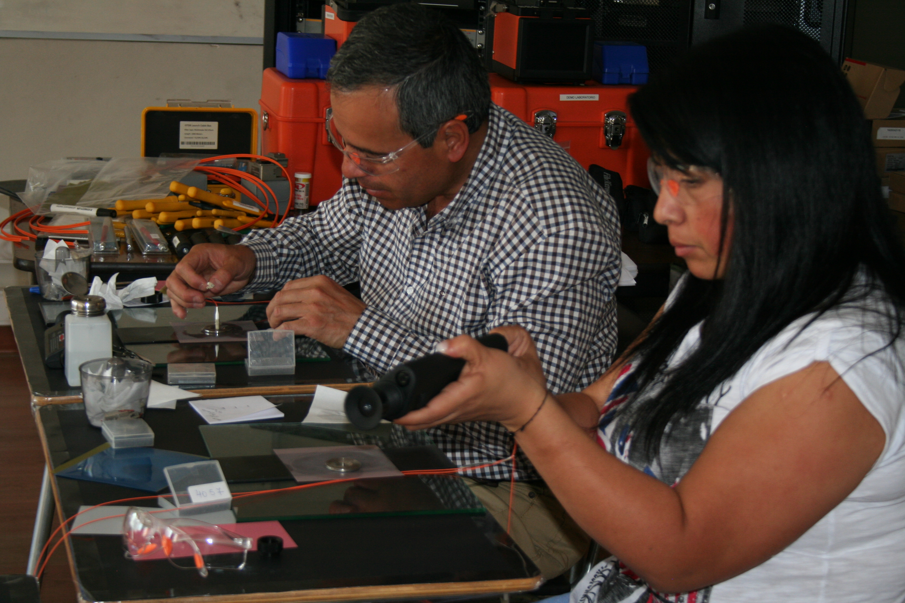 Alumnos trabajando en puestos individuales de laboratorio con fusionadora